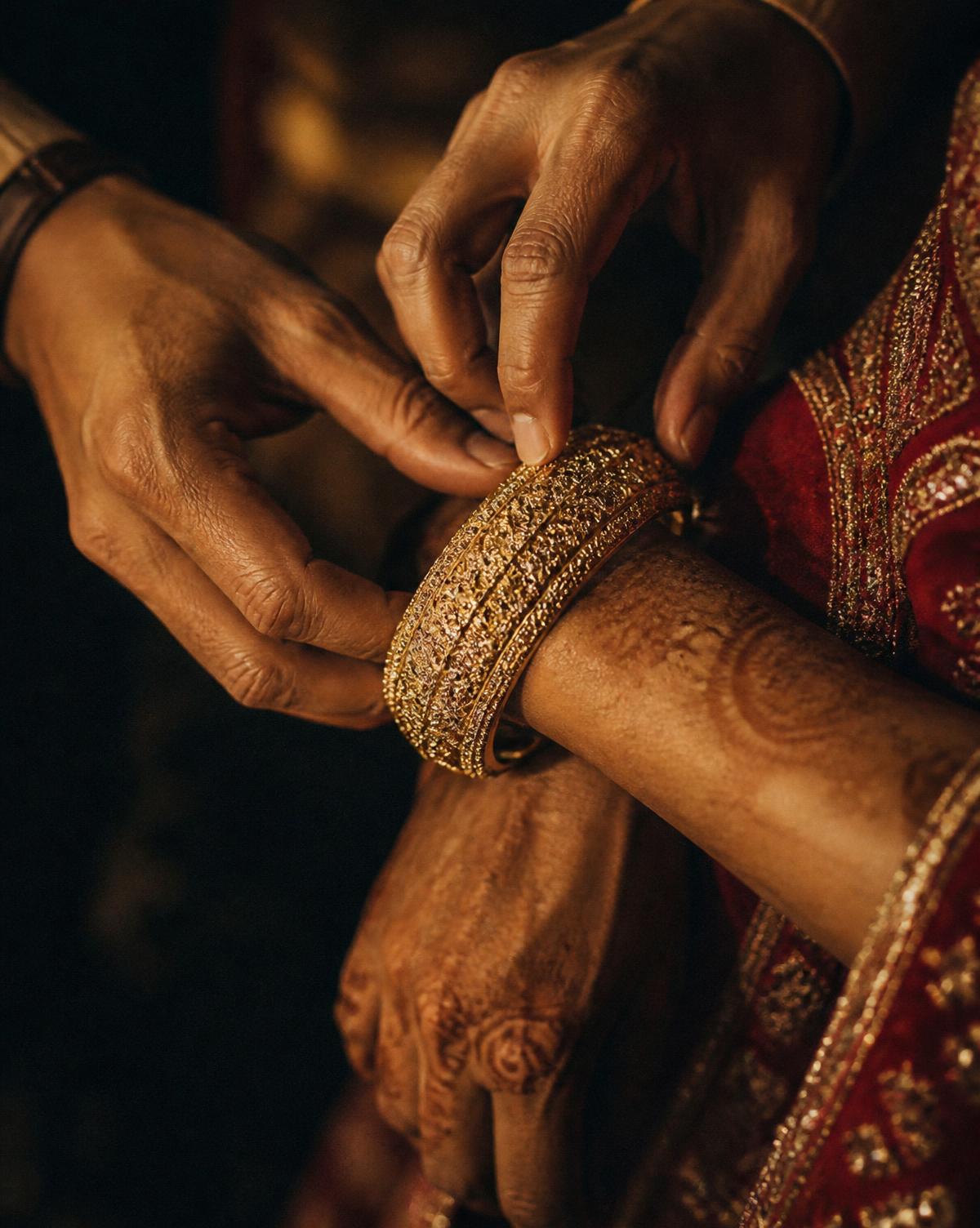 Hands fastening a gold bangle