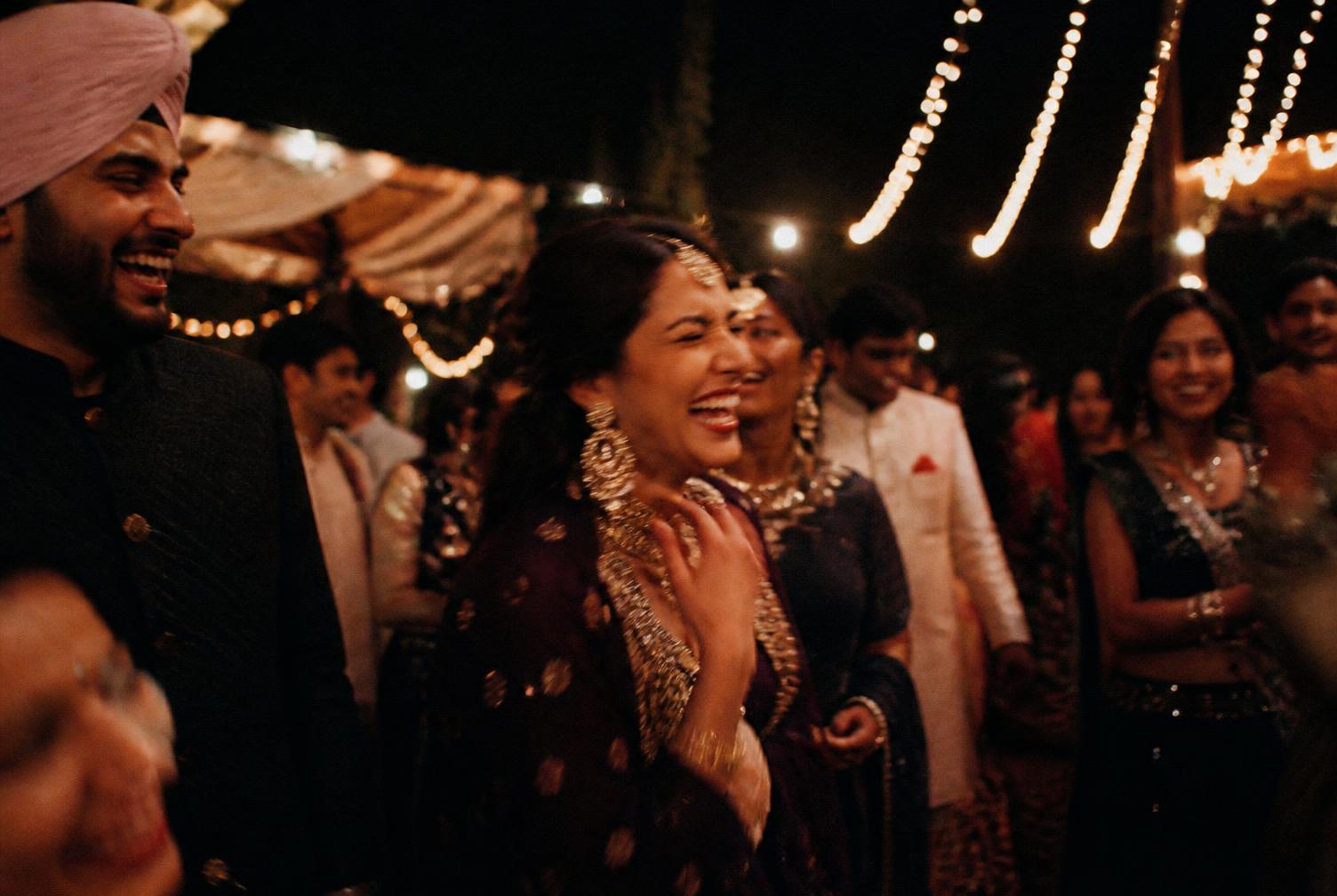 Guests laughing under string lights